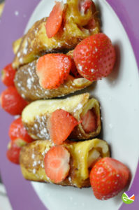 Une recette de pains perdus roulés à la fraise, du sucre glace.